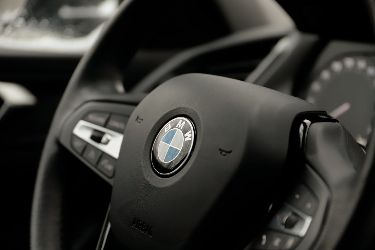 Detailed image of a BMW steering wheel inside a car's cockpit.